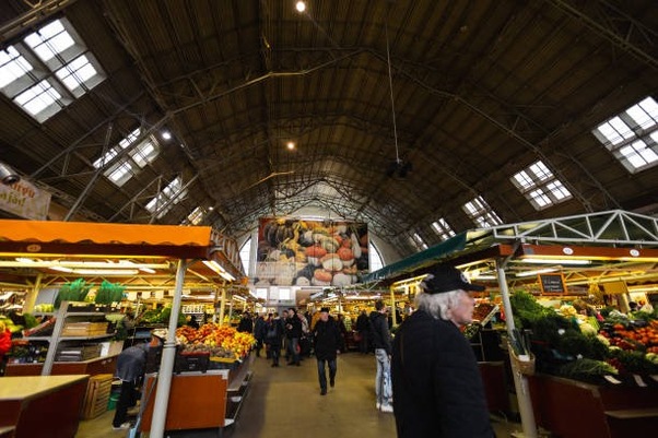 RIGA, LATVIA - MARCH 16, 2019: Riga Central market pavilion, people buying food - Former zeppelin hangars - Rigas Centraltirgus