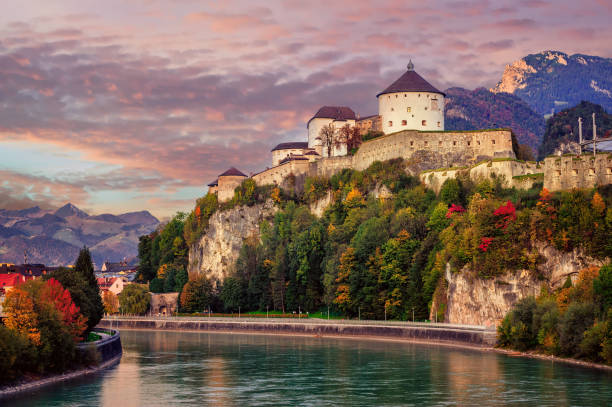 Kufstein Old Town with medieval fortress on a rock over the Inn river, Alps mountains, Austria, in dramatic sunset light