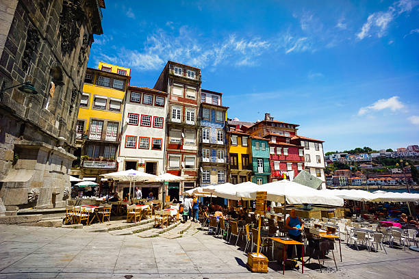 Porto, Potugal - June 11, 2015: Tourists visit restaurants at famous place Ribeira Square at day time